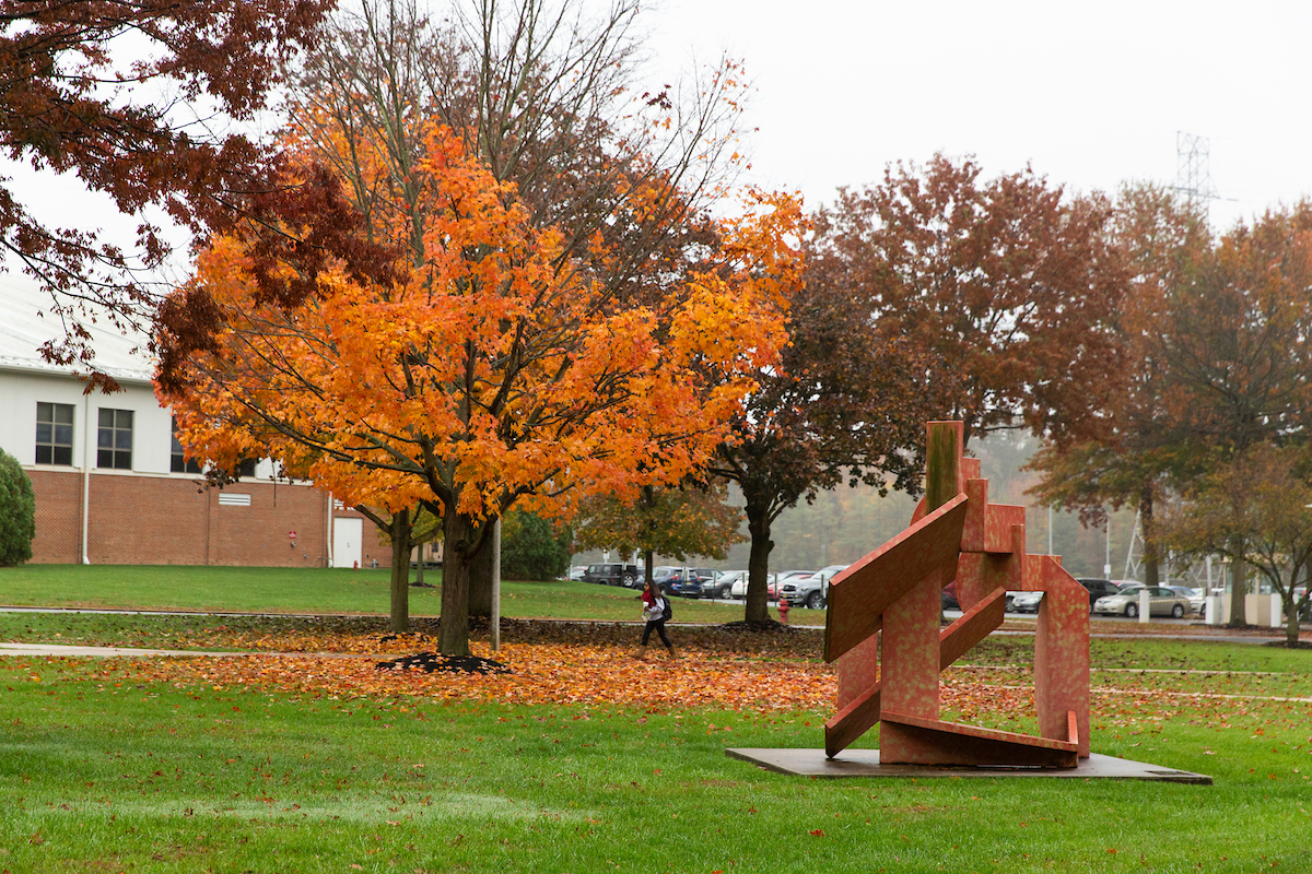 Student walks across campus in the fall.