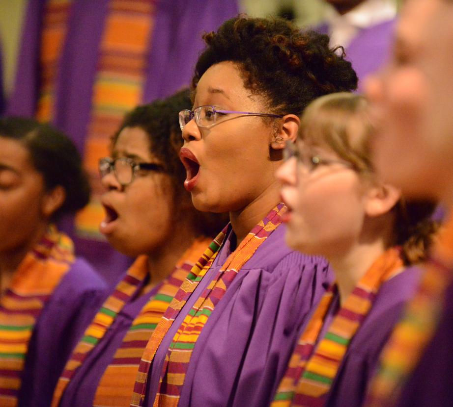 Group of female choral students dressed in vibrant colored robes