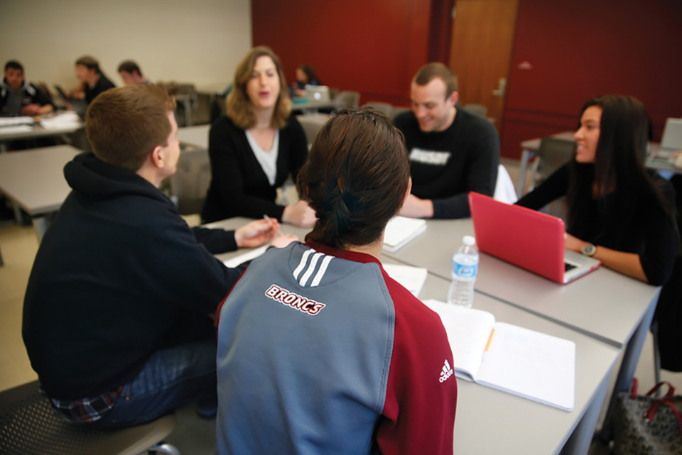 Students and faculty having a discussion around a table.