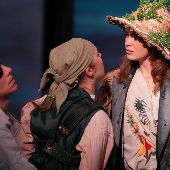 a woman with a hat with leaves and two pirates (actors).