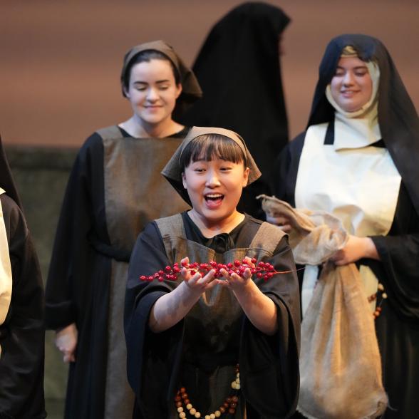 A singing woman holding a handful of berries.