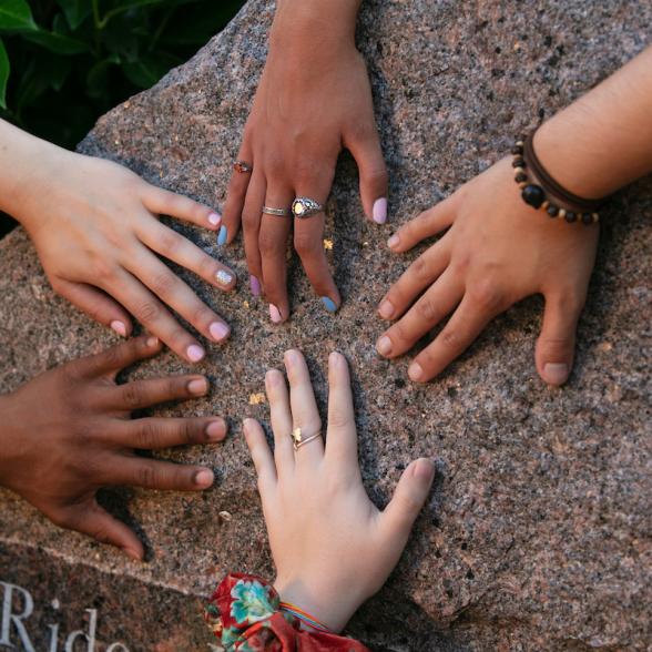 A variety of students' hands on the Rider Rock