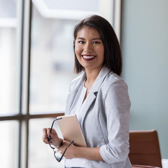 Business woman poses in office setting.