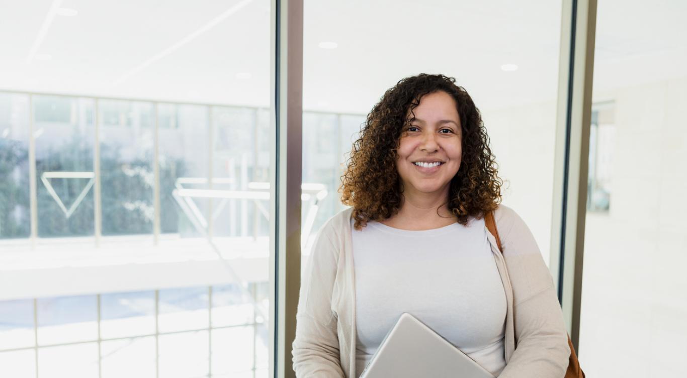 Woman holding computer smiles