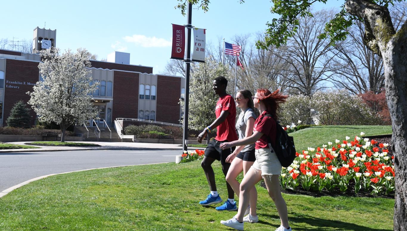 Three students walk on Rider campus.
