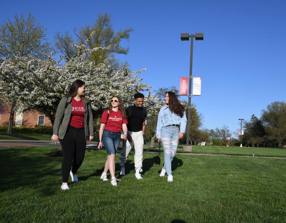 Four students walk across campus mall