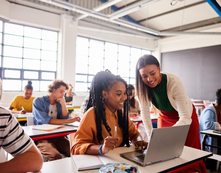 Teacher helps student with a class assignment