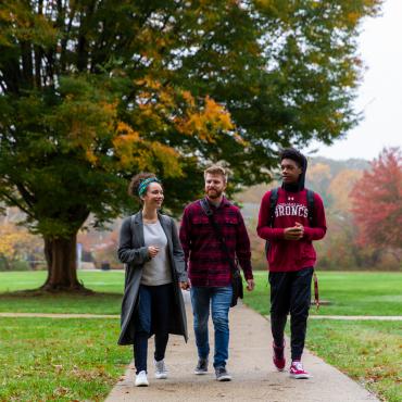 Three students walk to class in autumn